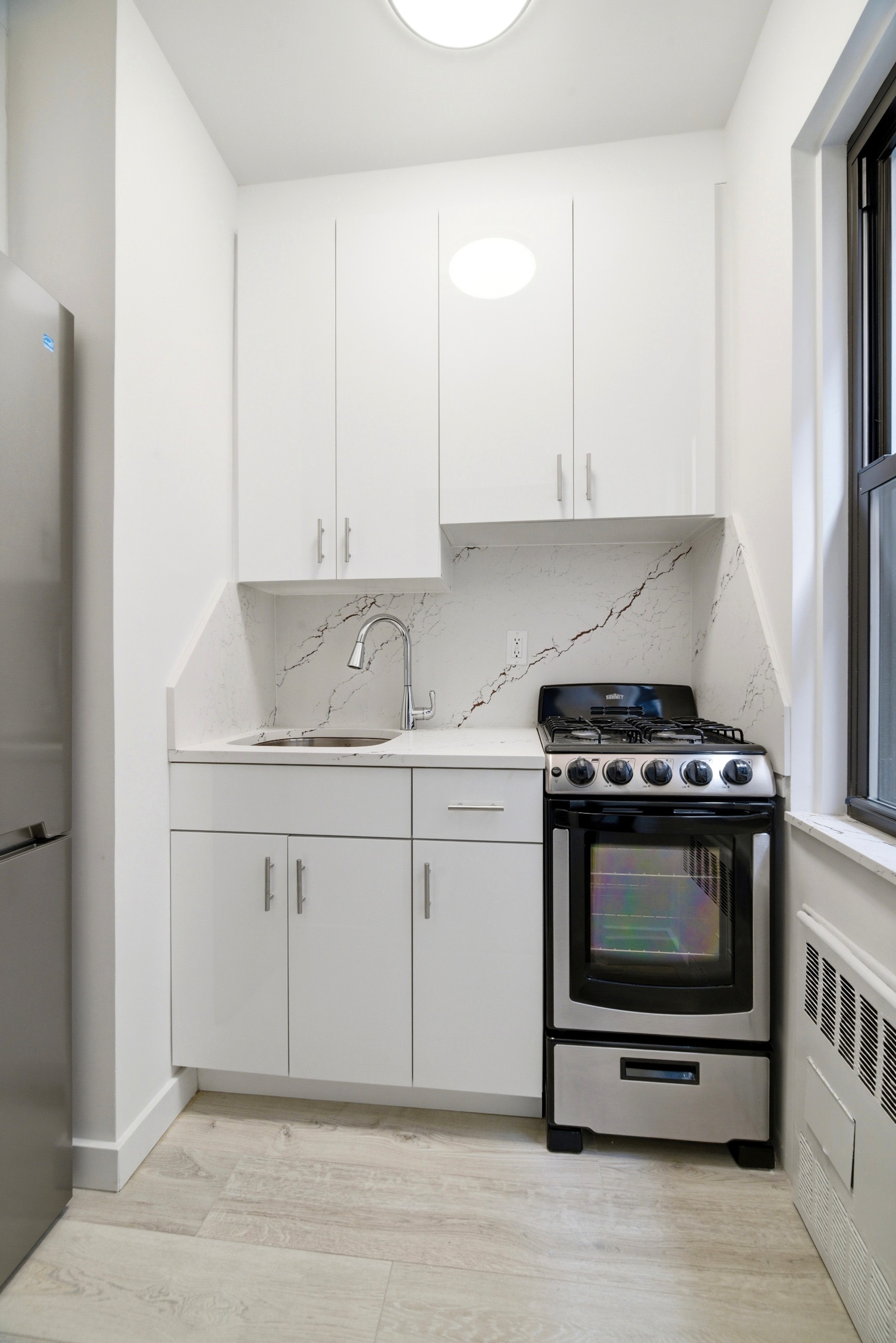 240 East 46th Street, Unit 8J Manhattan, NY 10017 - Photo 5 of 11 a kitchen with stainless steel appliances granite countertop a stove and a white cabinet