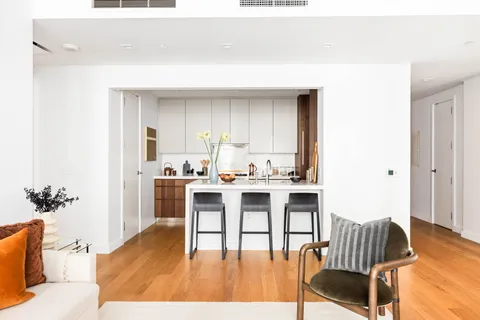 a living room with furniture and a dining table with kitchen view