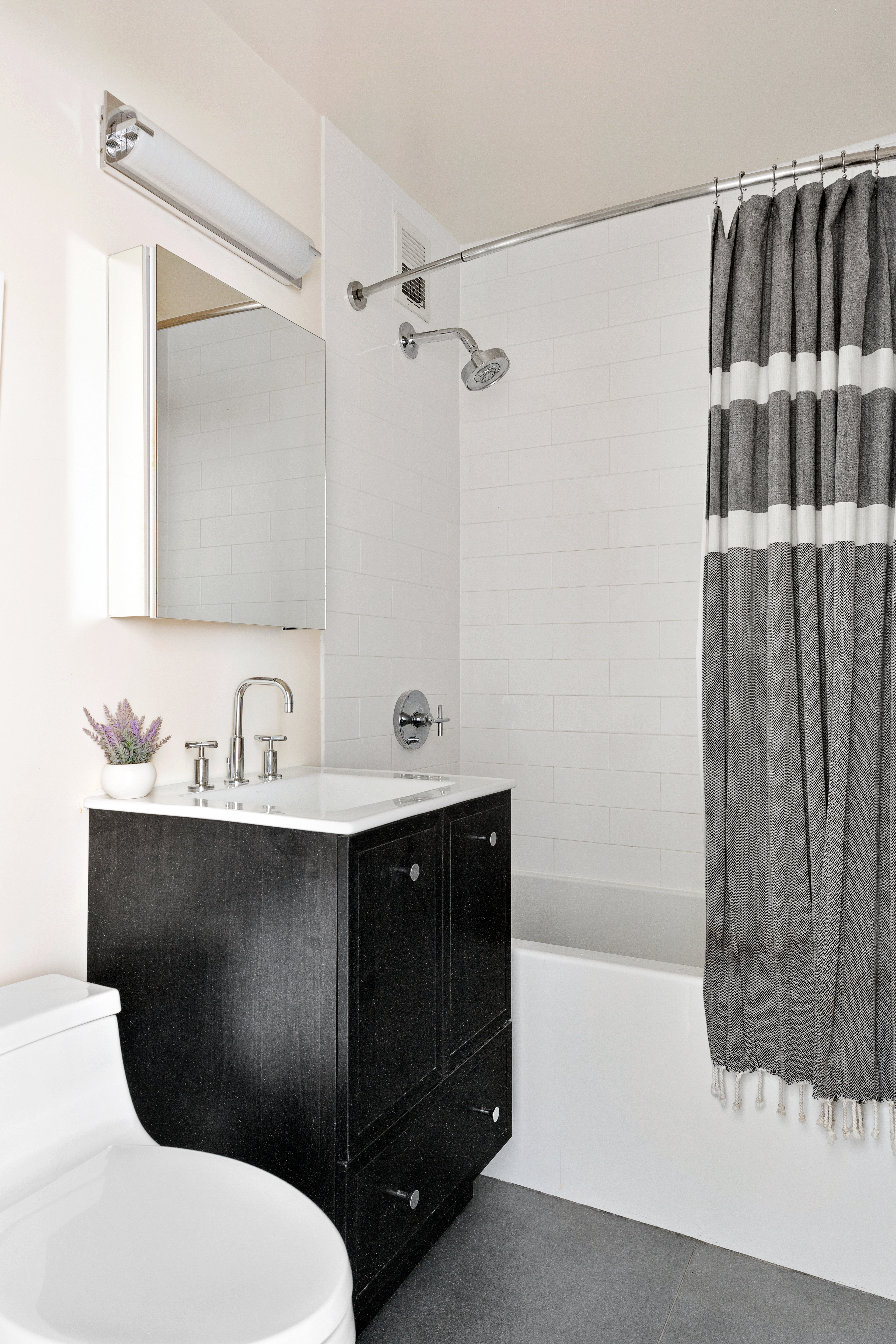 315 7th Avenue, Unit 9B Manhattan, NY 10001 - Photo 7 of 8 a bathroom with a sink a toilet and shower