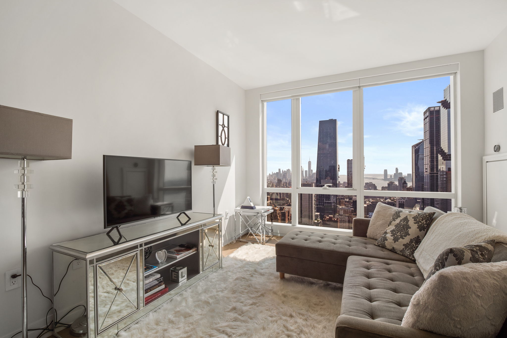 460 West 42nd Street, Unit 55F Manhattan, NY 10036 - Photo 2 of 9 a living room with furniture and a flat screen tv