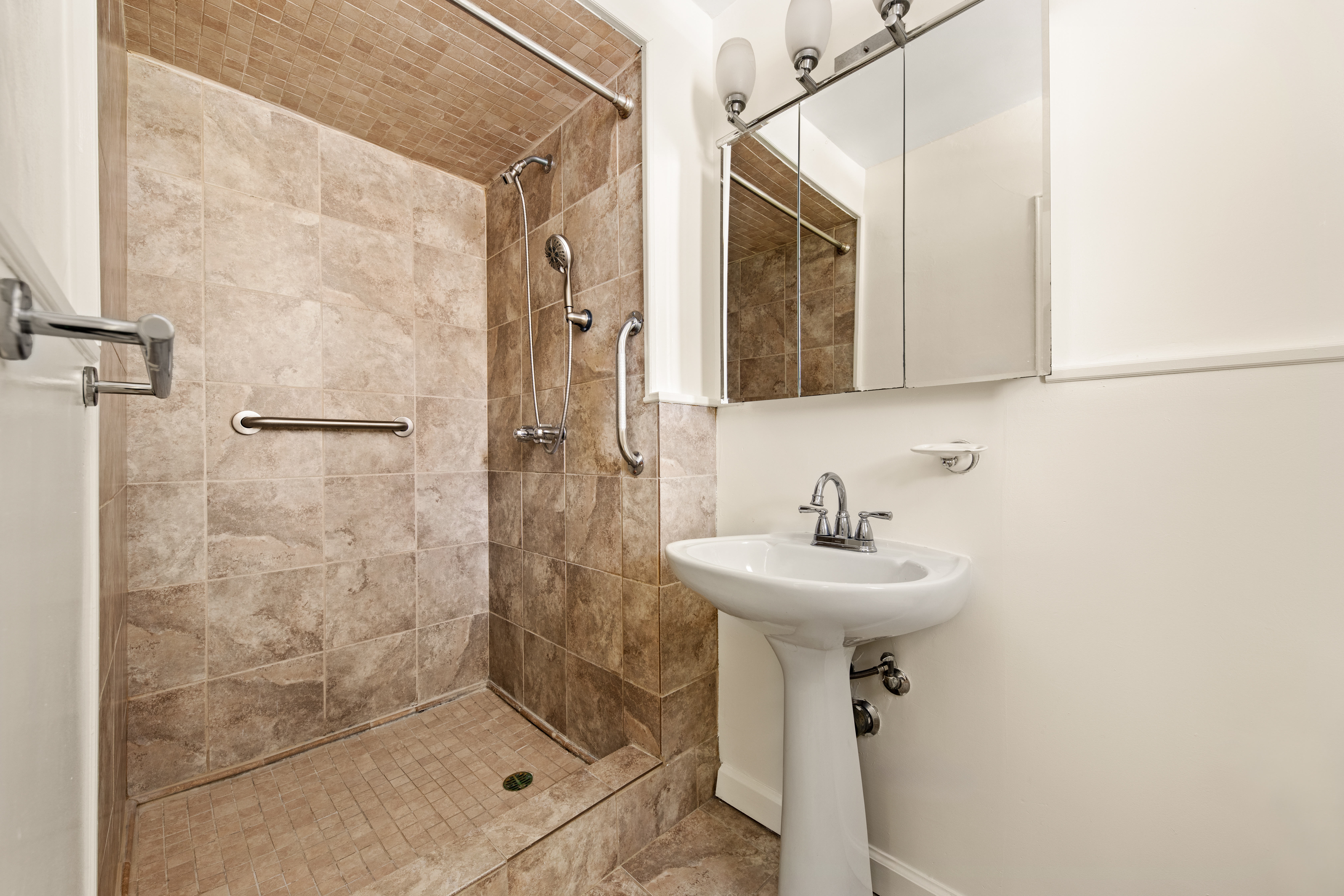 185 Prospect Park Southwest, Unit 301 Brooklyn, NY 11218 - Photo 5 of 9 a bathroom with a sink a mirror and shower
