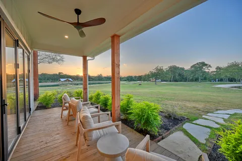 a view of a patio with lawn chairs floor to ceiling window and lake view