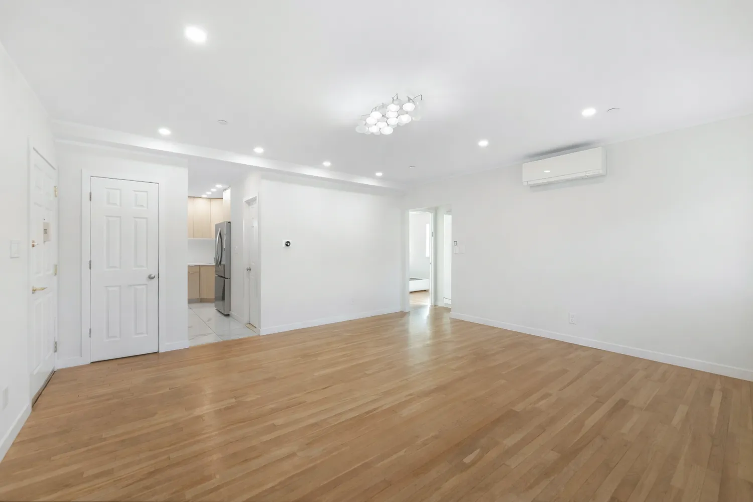 a view of an empty room with wooden floor