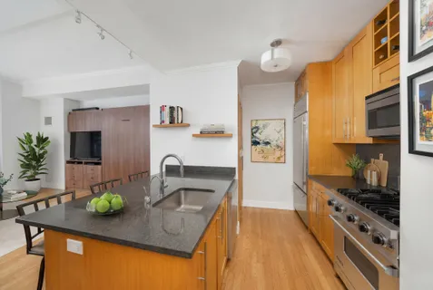 a kitchen with stainless steel appliances granite countertop a sink a stove and a refrigerator