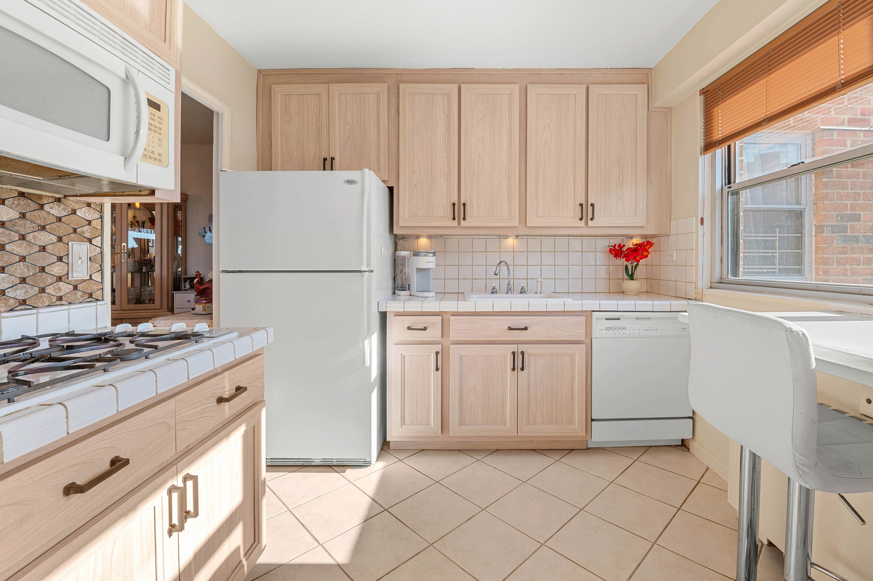 70-31 108th Street, Unit 9C Queens, NY 11375 - Photo 3 of 11 a kitchen with cabinets appliances a sink and a window