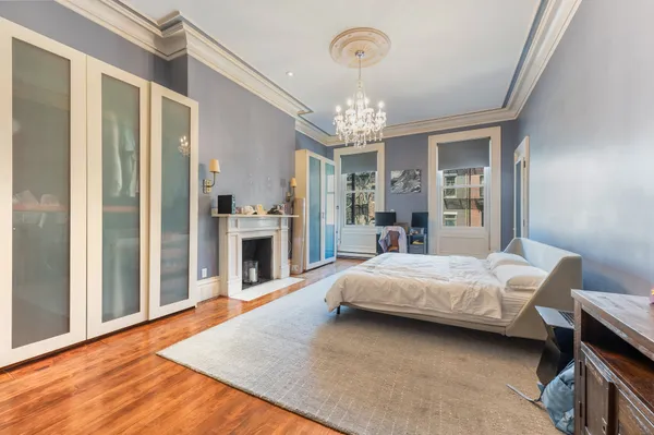 a spacious bedroom with a bed chandelier and a window