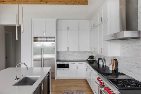 a kitchen with stainless steel appliances granite countertop a sink stove and refrigerator