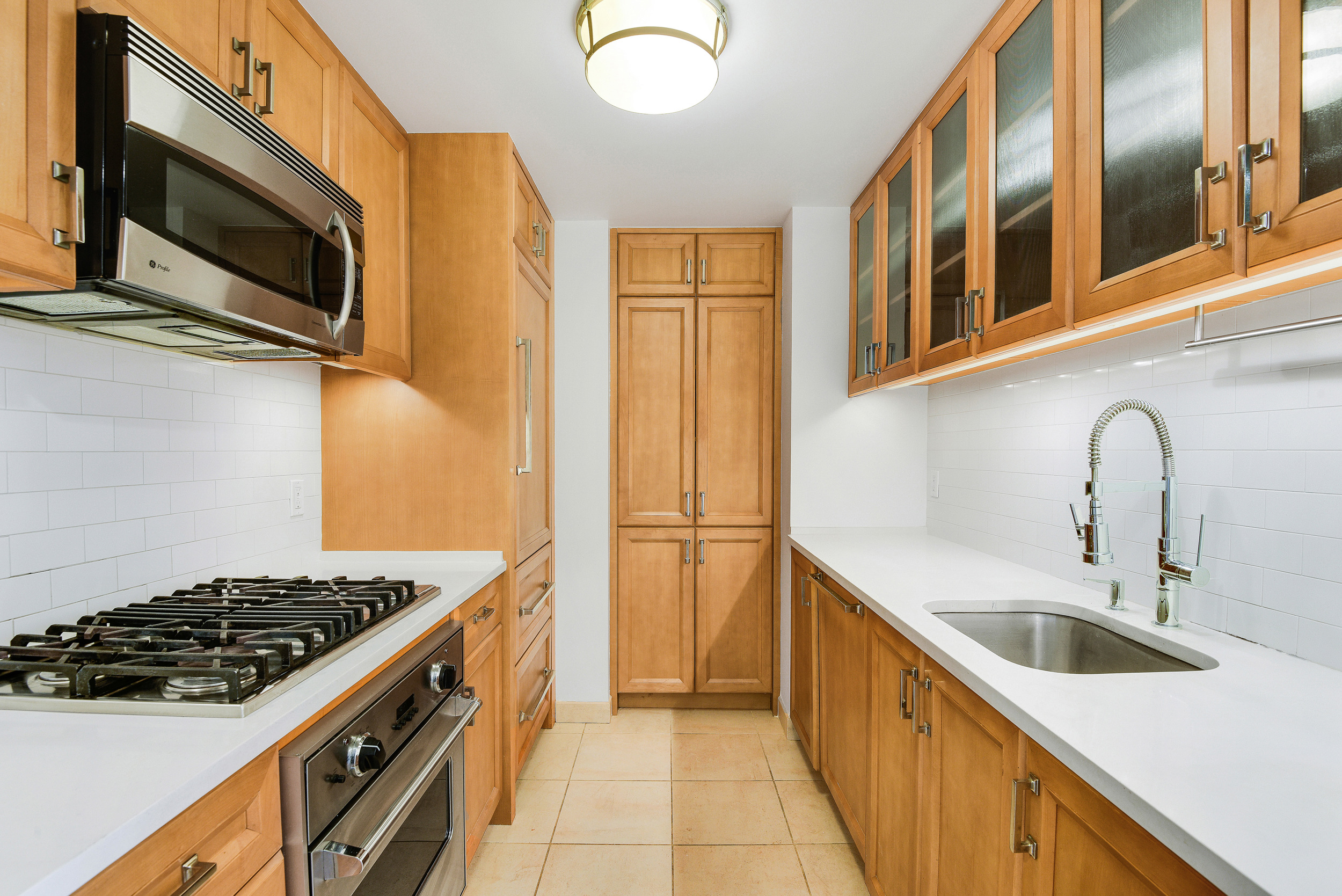 205 East 85th Street, Unit 12H Manhattan, NY 10028 - Photo 9 of 19 a kitchen with stainless steel appliances granite countertop a sink and a stove