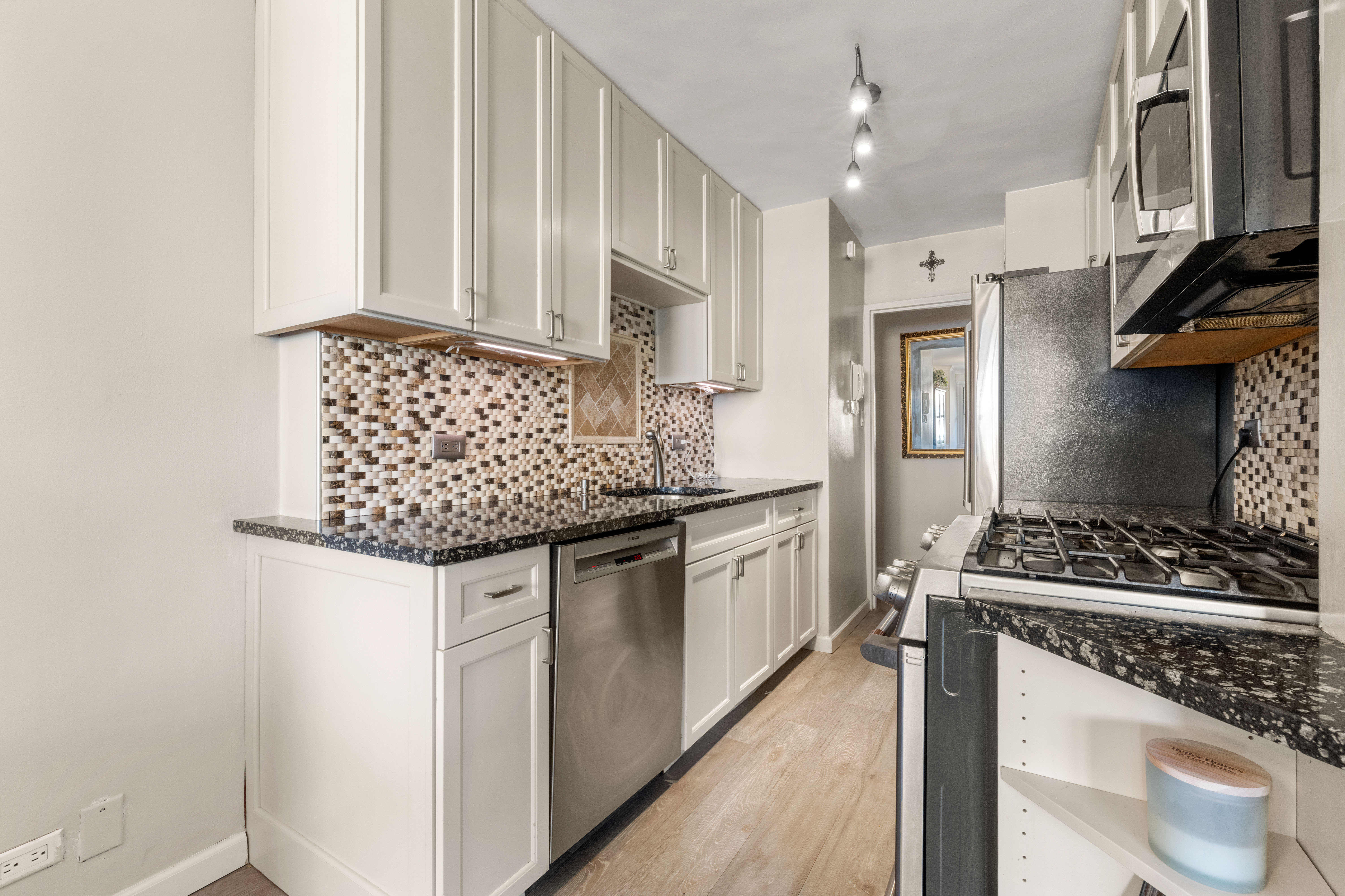 102-30 66th Road, Unit 7E Queens, NY 11375 - Photo 6 of 15 a kitchen with stainless steel appliances granite countertop a sink stove and cabinets