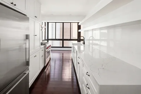 a large white kitchen with a large window