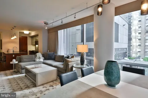 a living room with furniture a large window and a chandelier