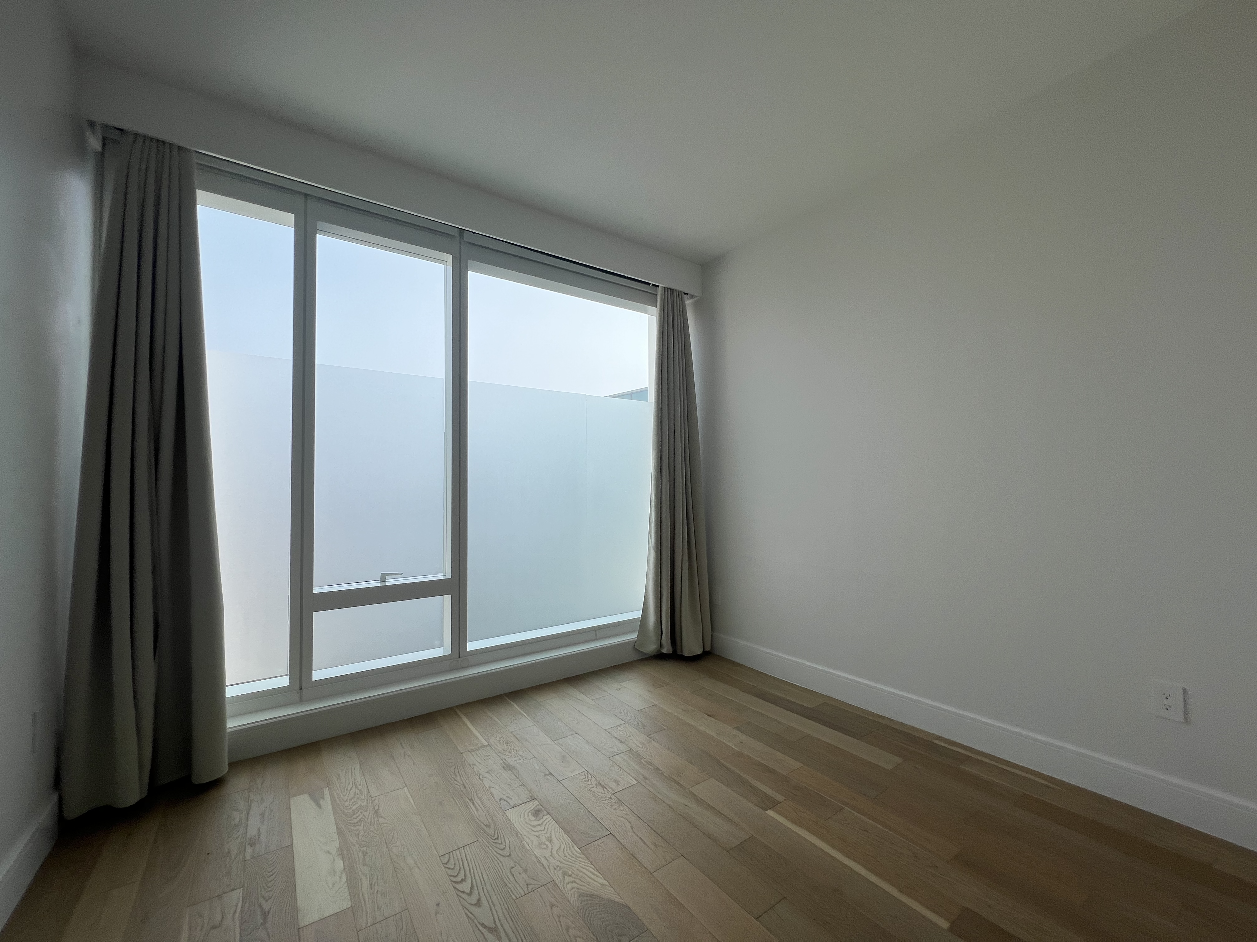 37-34 33rd Street, Unit 7H Queens, NY 11101 - Photo 11 of 18 a view of a small space with wooden floor and a window