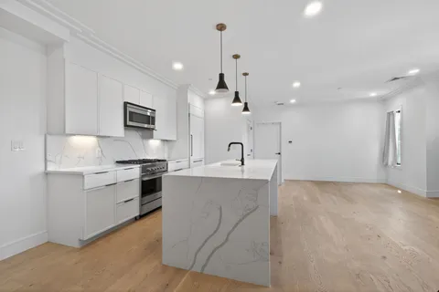 a large kitchen with kitchen island a sink stainless steel appliances and cabinets