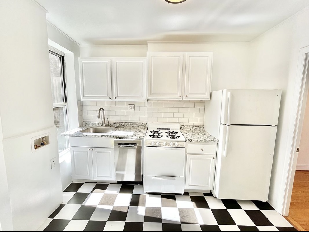 80 East 7th Street, Unit 4C Manhattan, NY 10003 - Photo 3 of 7 a kitchen with a checkered floor and white cabinets