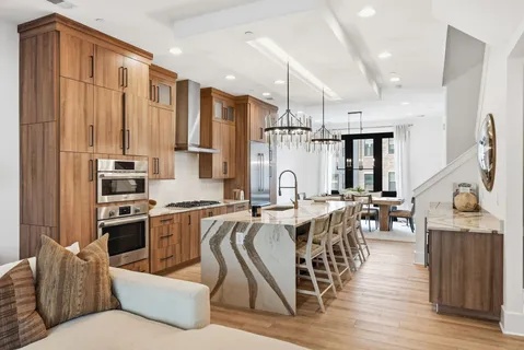 a kitchen with stainless steel appliances kitchen island granite countertop a stove a sink dishwasher and a refrigerator with wooden floor