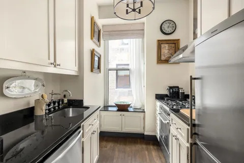 a kitchen with stainless steel appliances granite countertop a sink a stove and cabinets