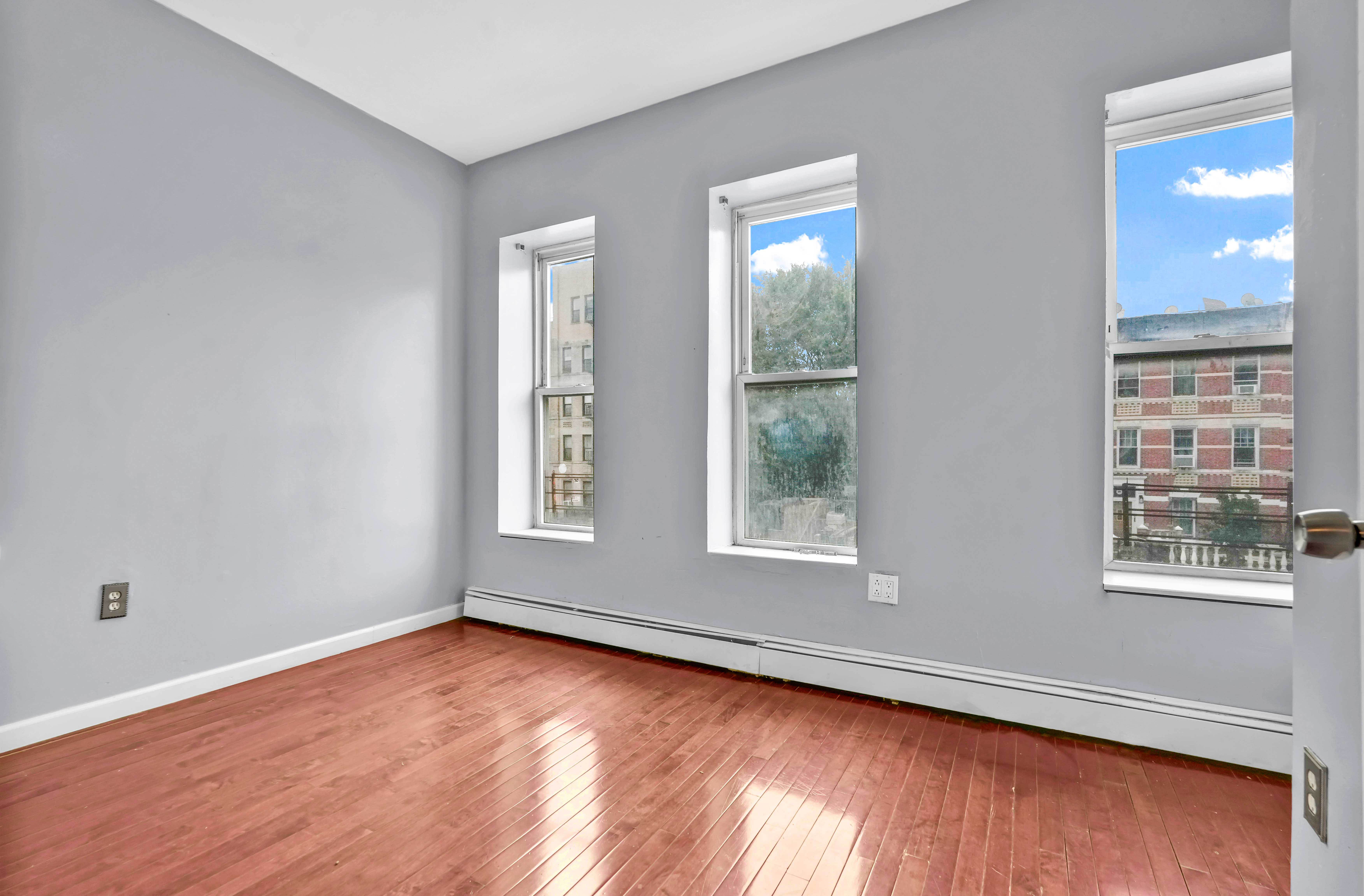 1633 St Johns Place, Unit 3 Brooklyn, NY 11233 - Photo 2 of 29 an empty room with wooden floor and windows