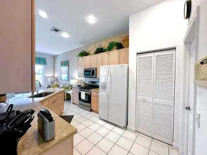 a kitchen with kitchen island a counter top space a sink a refrigerator and cabinets