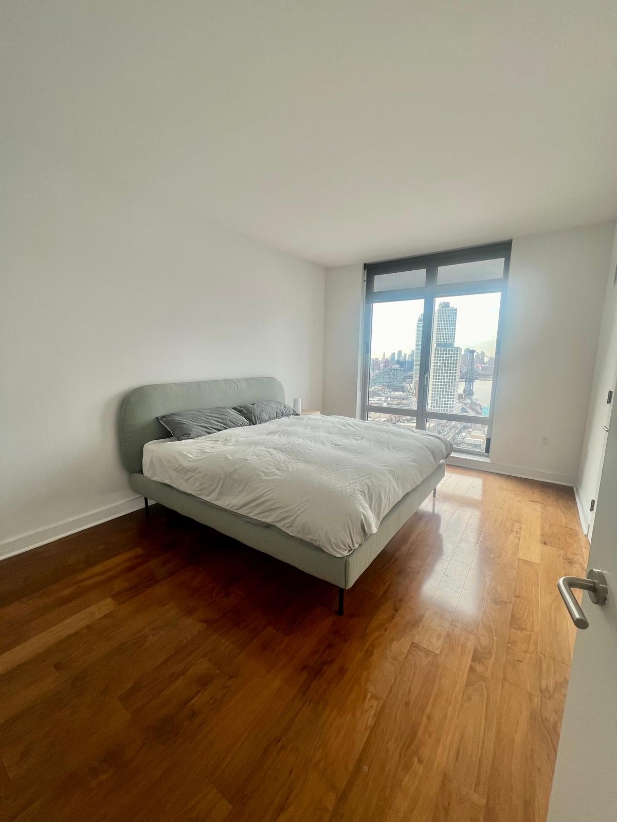 2 Northside Piers, Unit 26C Brooklyn, NY 11249 - Photo 8 of 21 a bedroom with a bed and wooden floor