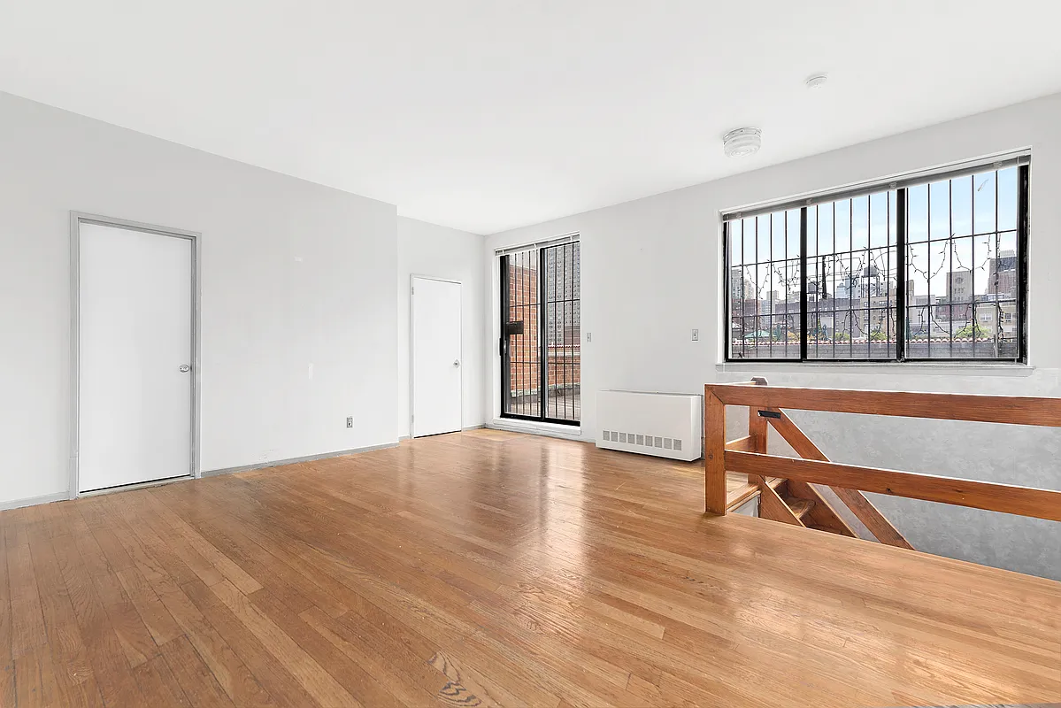 221 East 82nd Street, Unit 6A Manhattan, NY 10028 - Photo 5 of 11 a view of an empty room with wooden floor and a window