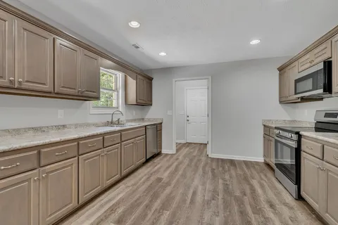 a kitchen with stainless steel appliances granite countertop a stove a sink and a refrigerator