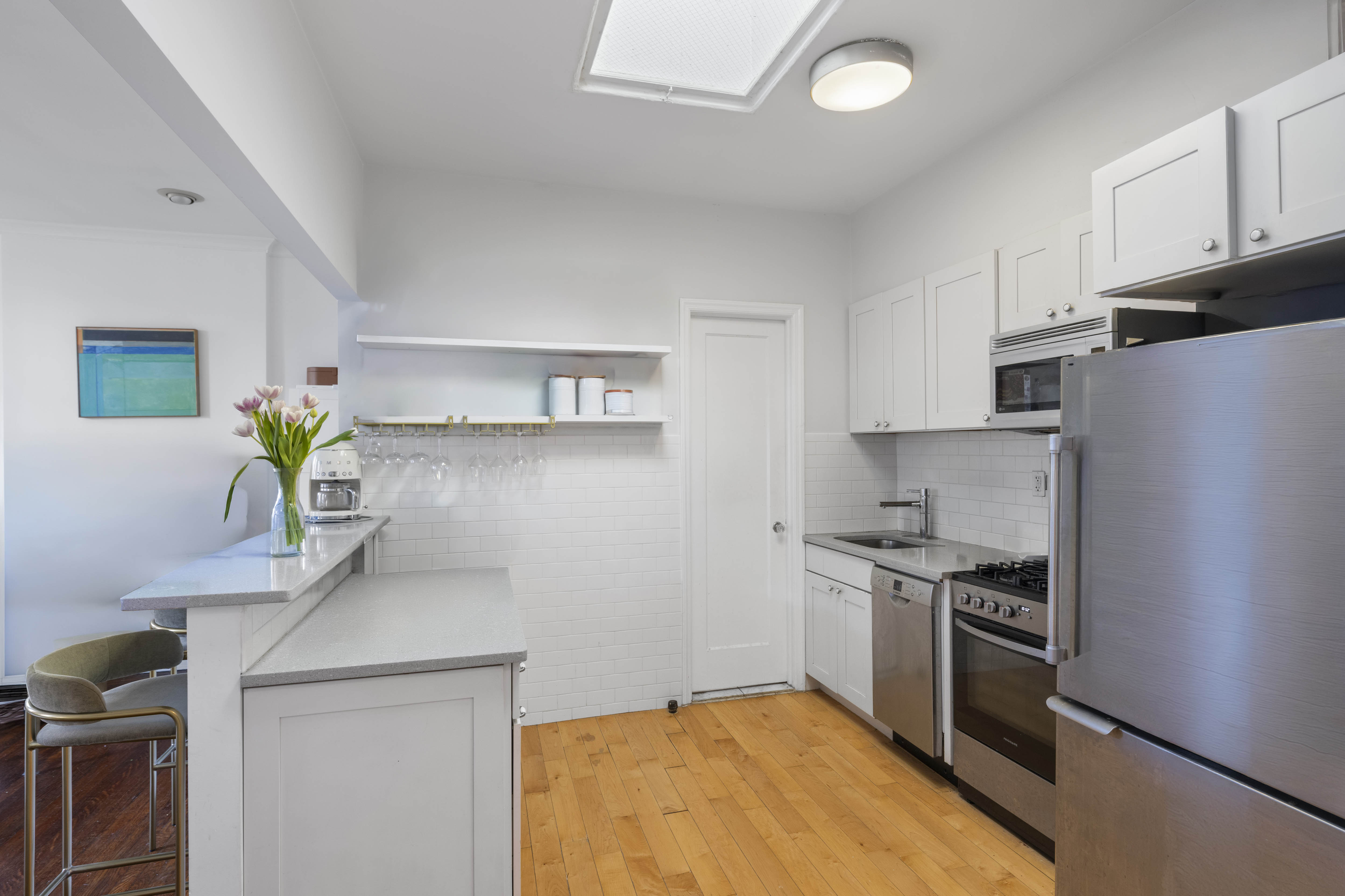21 Monroe Place, Unit 5F Brooklyn, NY 11201 - Photo 3 of 10 a kitchen with stainless steel appliances a sink a stove and a refrigerator