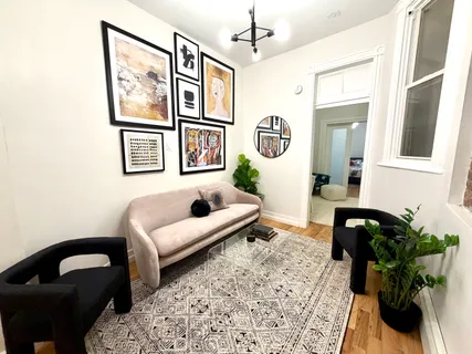 a living room with furniture and a painting on the wall