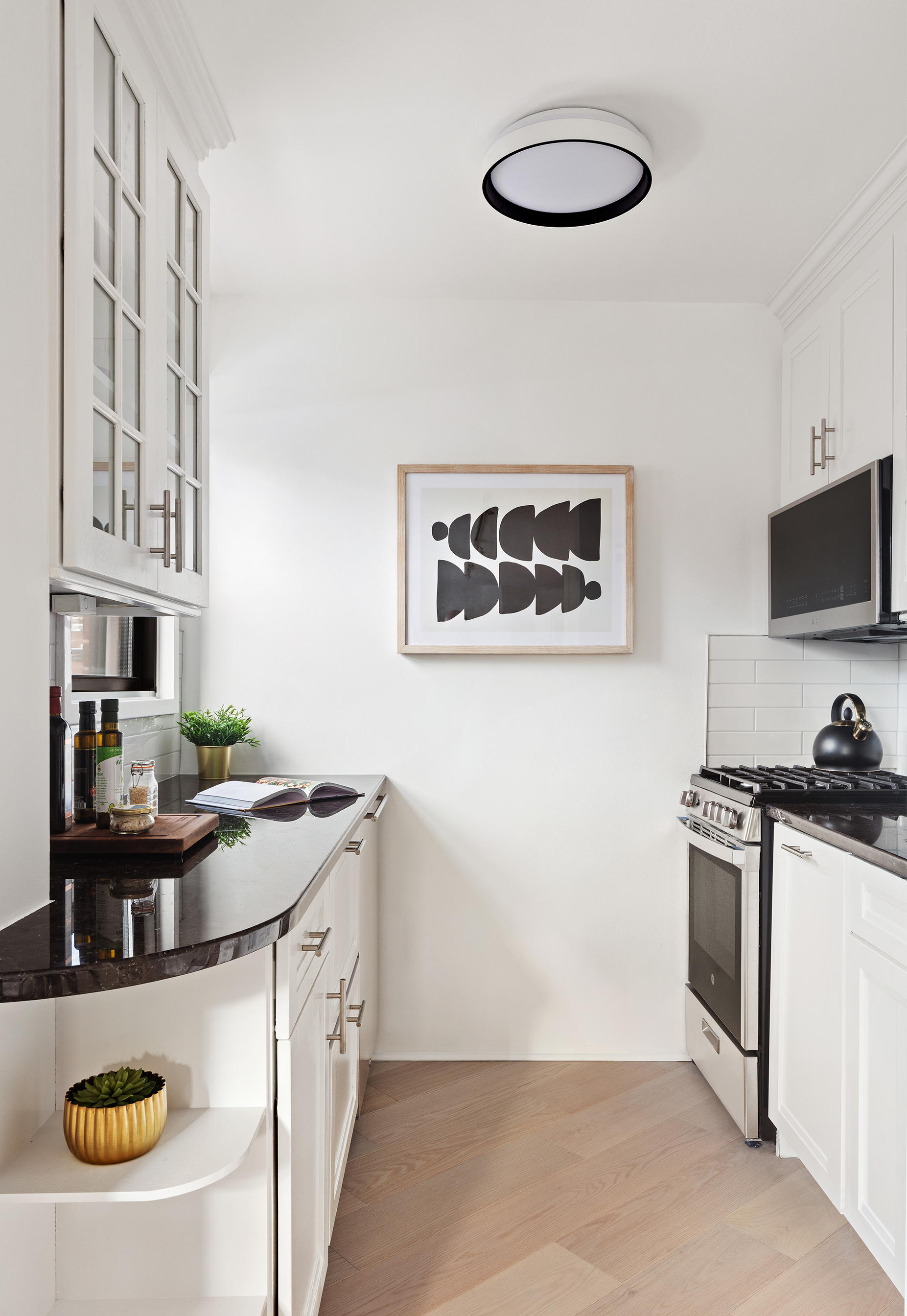 31 Jane Street, Unit 5A Manhattan, NY 10014 - Photo 6 of 13 a kitchen with stainless steel appliances granite countertop a stove and a microwave