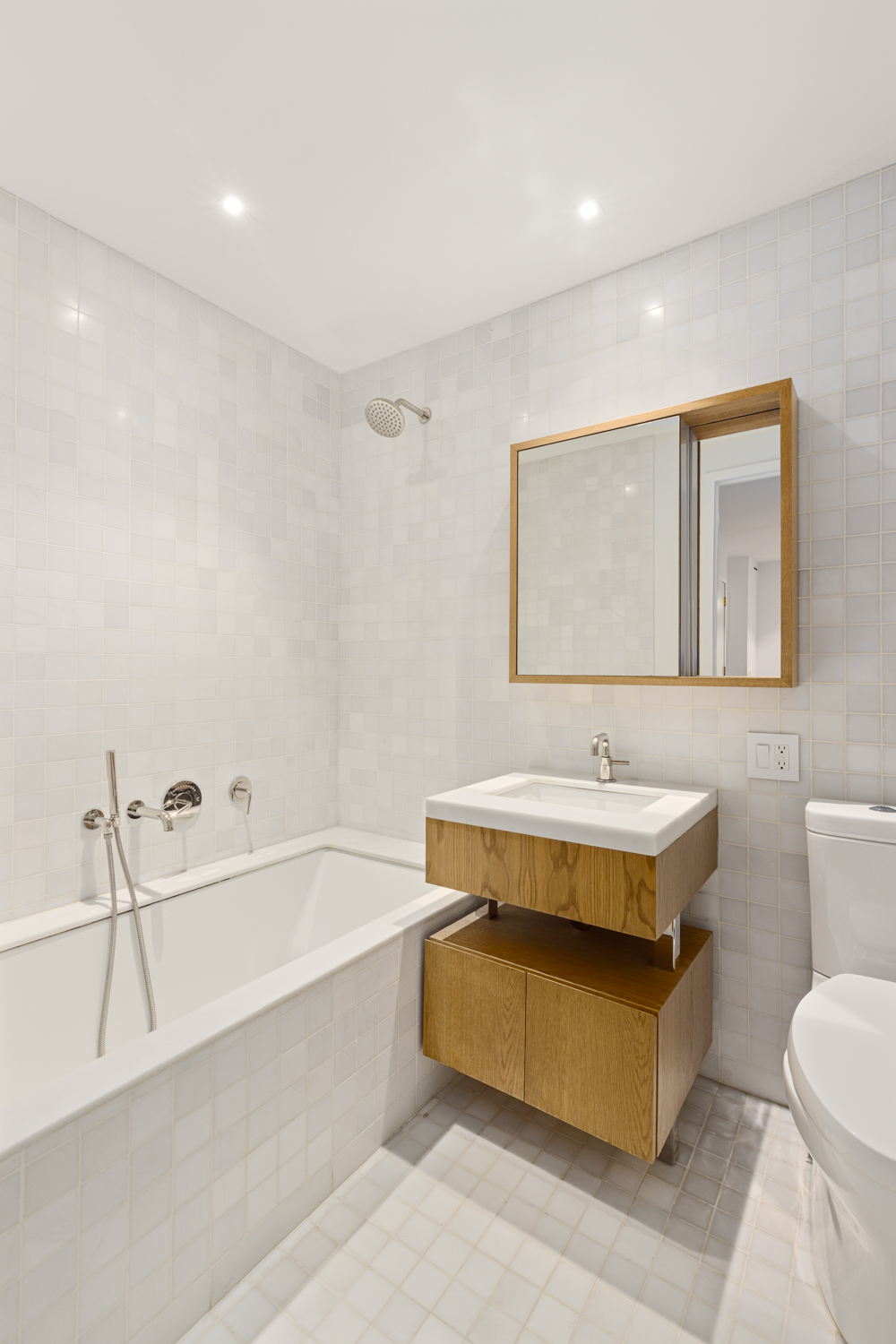 30 Warren Street, Unit 2A Manhattan, NY 10007 - Photo 9 of 10 a bathroom with a tub sink and mirror