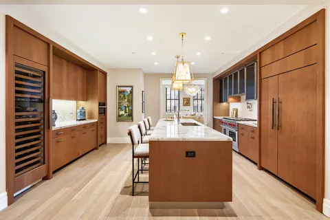 a kitchen with stainless steel appliances granite countertop a refrigerator a sink dishwasher and a stove with wooden floor