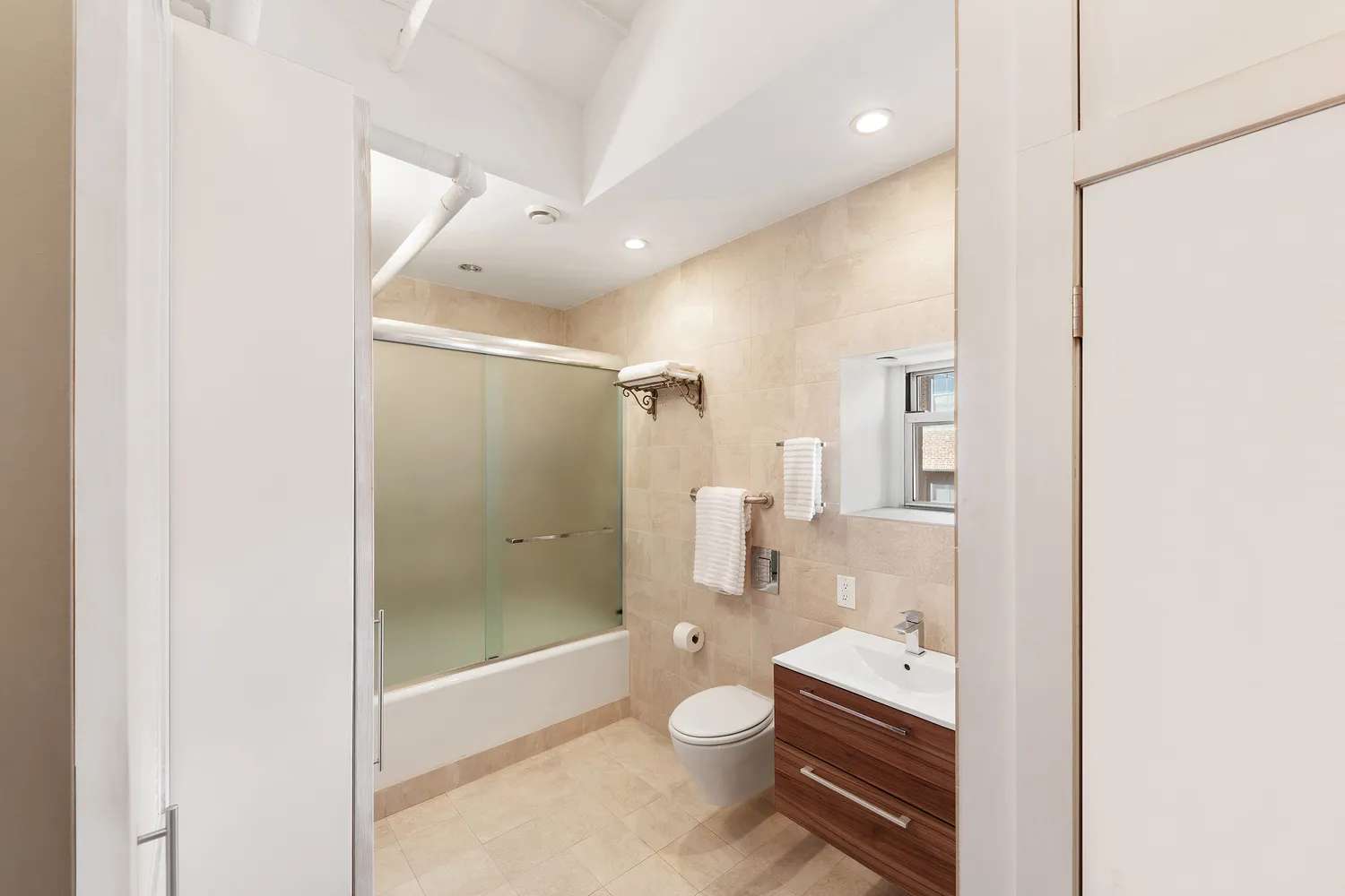 a bathroom with a glass shower door and a toilet