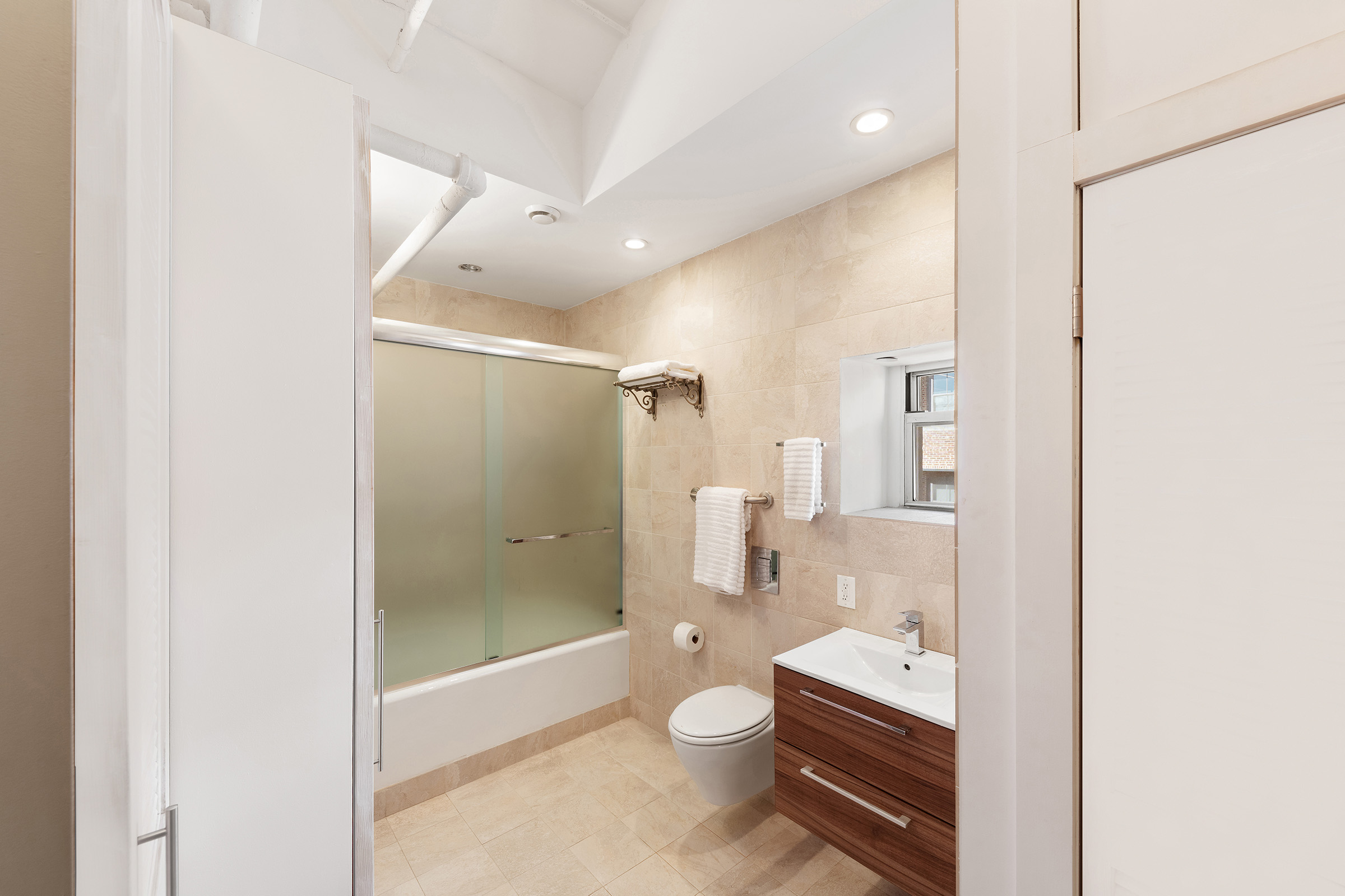 543 Broadway, Unit PH Manhattan, NY 10012 - Photo 9 of 14 a bathroom with a glass shower door and a toilet