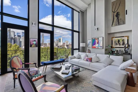 a living room with furniture and floor to ceiling windows