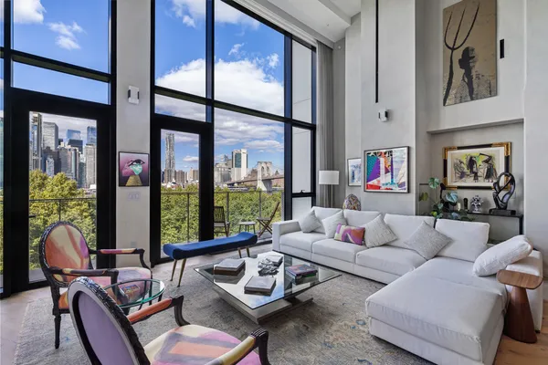 a living room with furniture and floor to ceiling windows