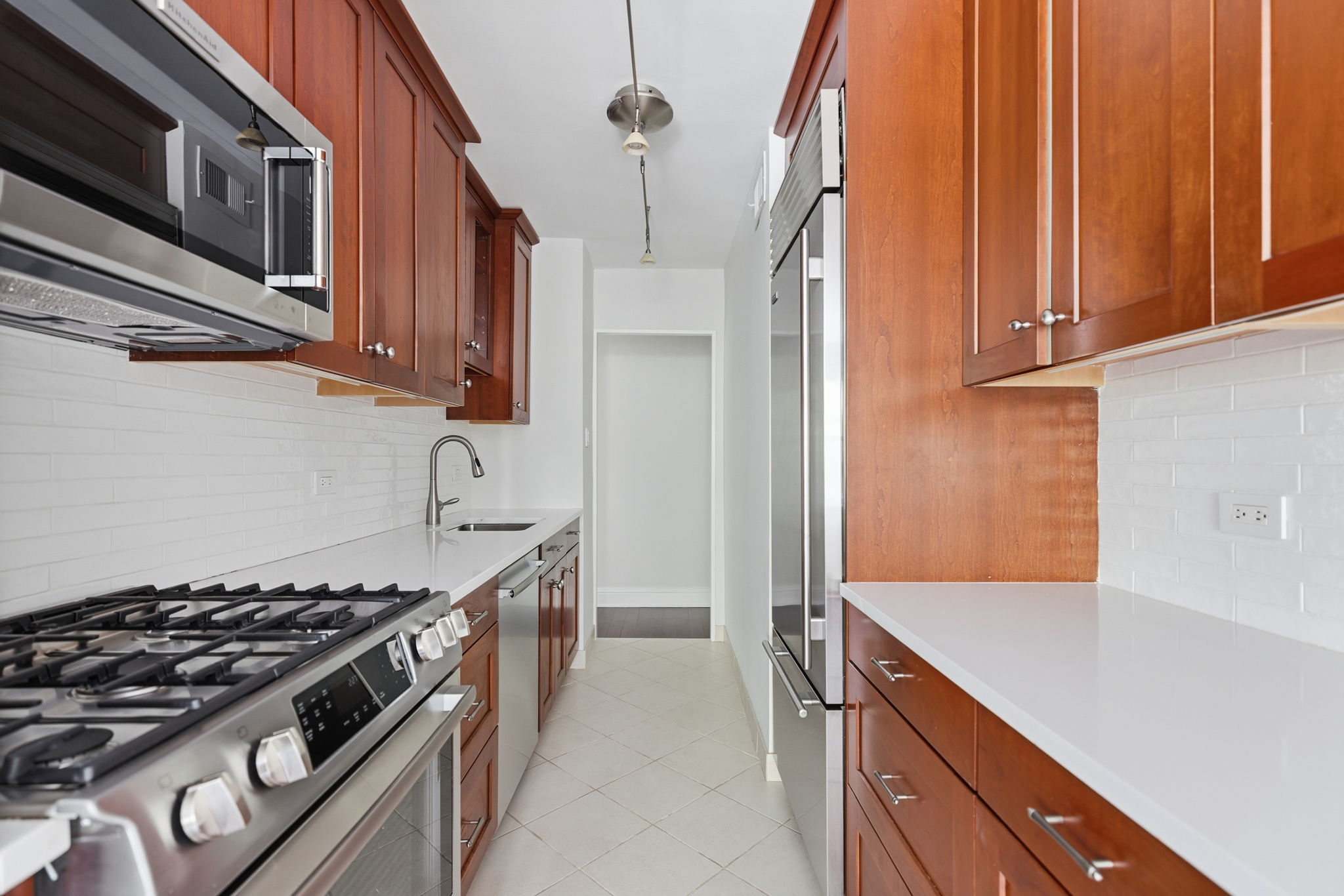 360 East 72nd Street, Unit A306 Manhattan, NY 10021 - Photo 3 of 17 a kitchen with stainless steel appliances granite countertop a stove and a refrigerator
