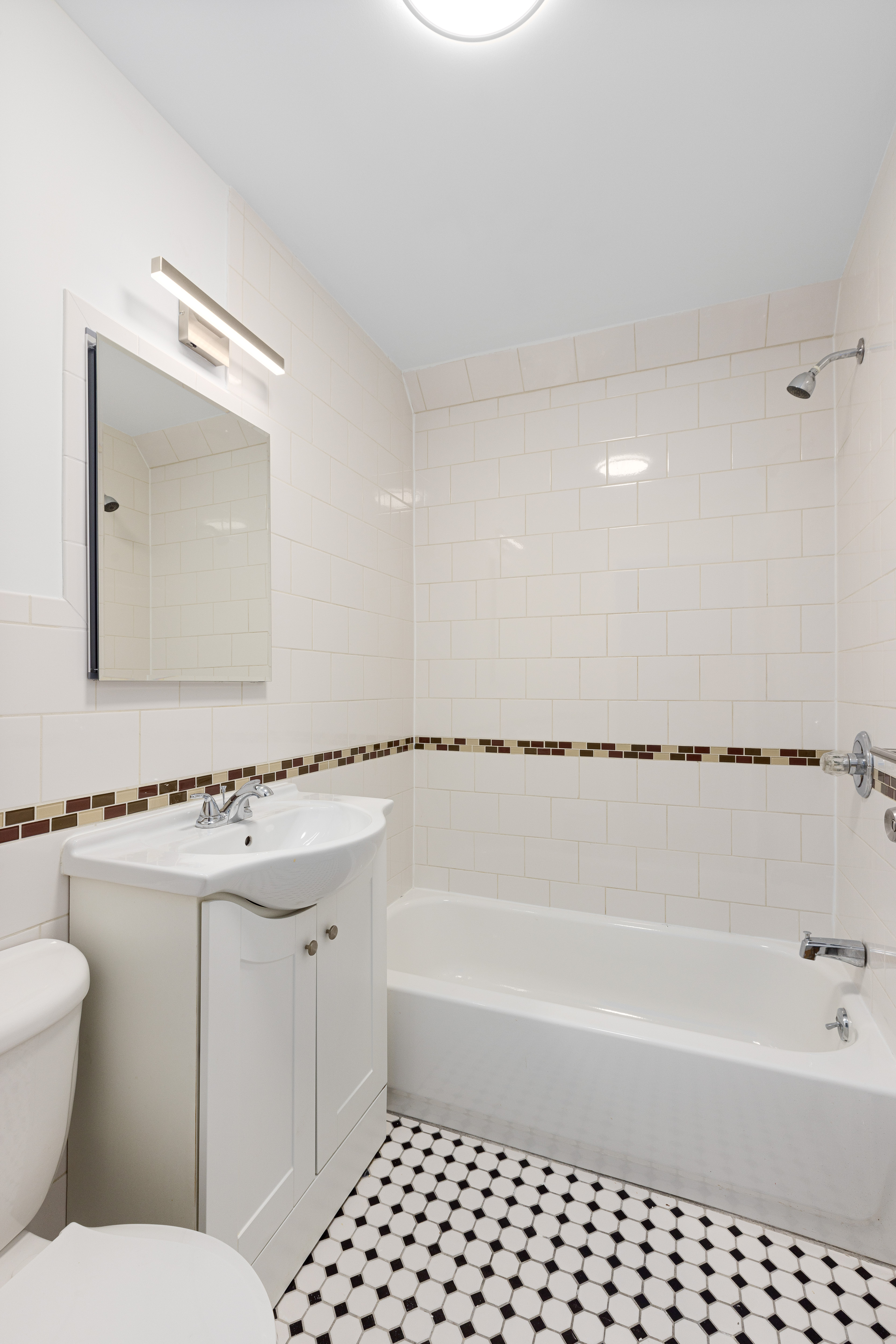 239 East 7th Street, Unit 1 Manhattan, NY 10009 - Photo 5 of 9 a bathroom with a sink a toilet and shower