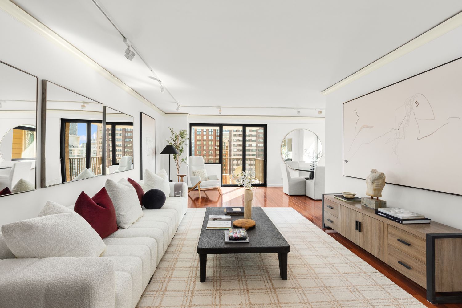 a living room with furniture large windows and a chandelier
