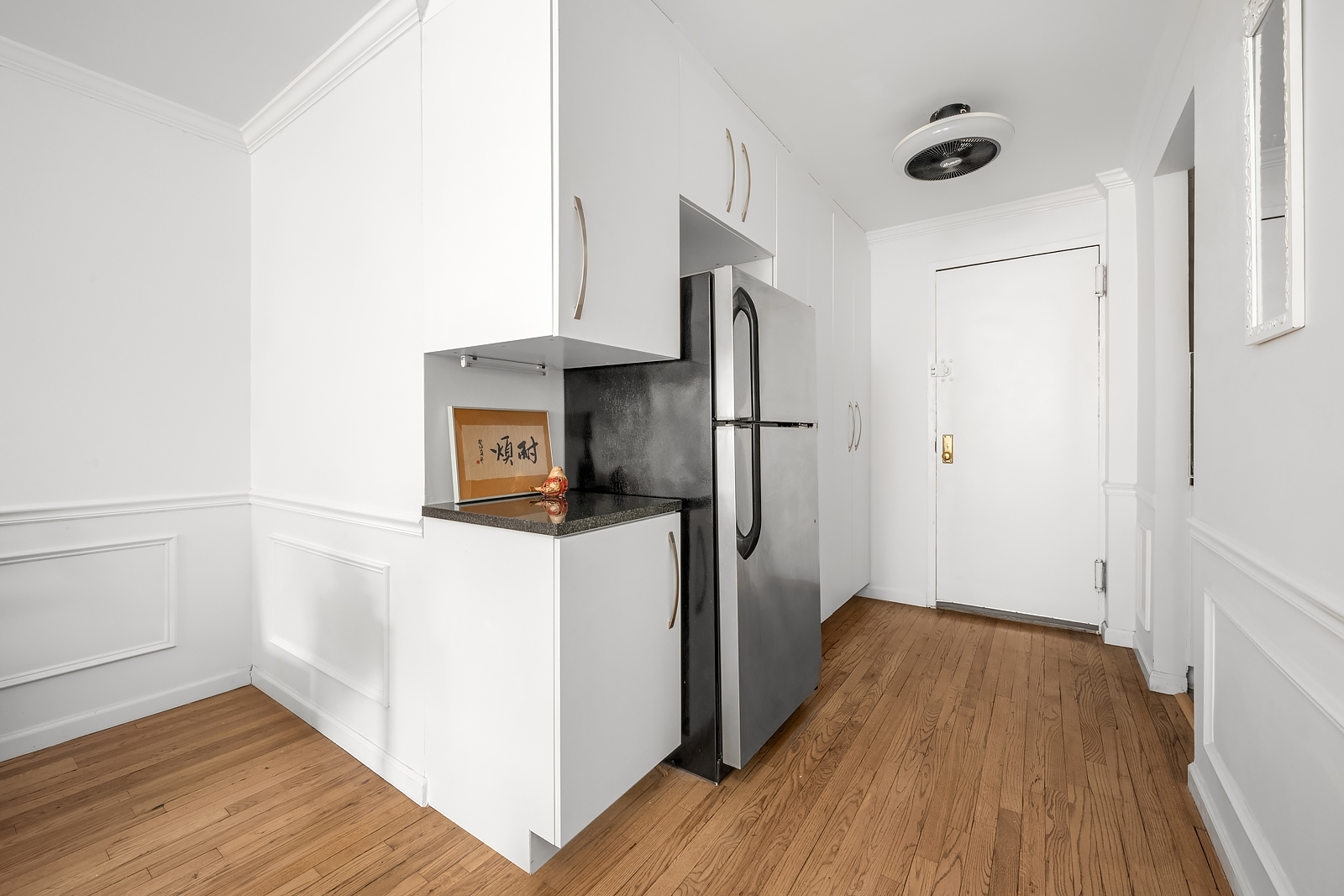 215 East 77th Street, Unit 4C Manhattan, NY 10075 - Photo 3 of 7 a kitchen with a refrigerator and wooden floor