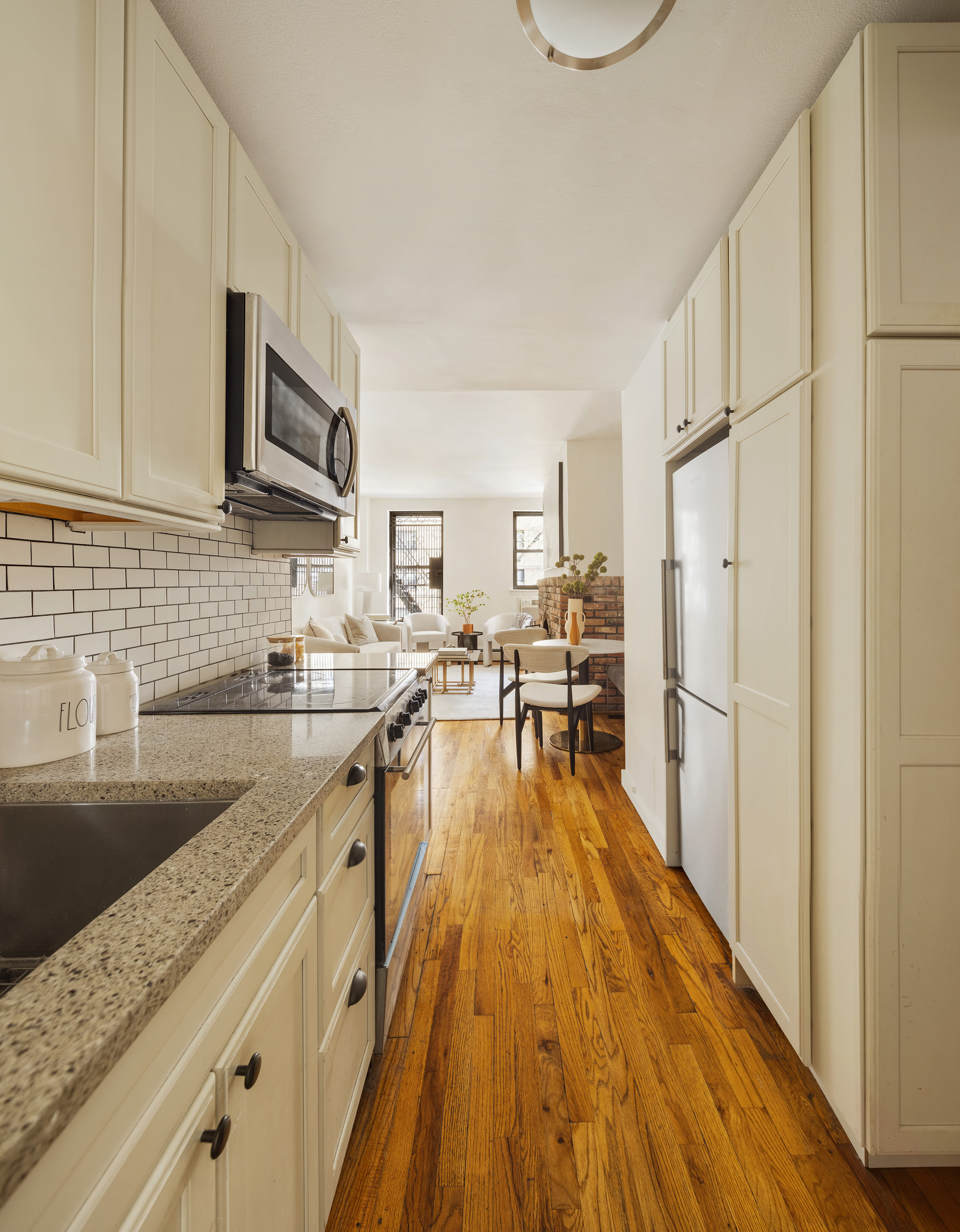 410 West 25th Street, Unit 2B Manhattan, NY 10001 - Photo 2 of 9 a kitchen with granite countertop a sink appliances and cabinets