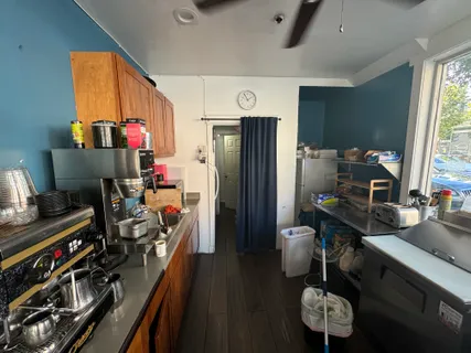 a kitchen with stainless steel appliances a stove refrigerator and a couch