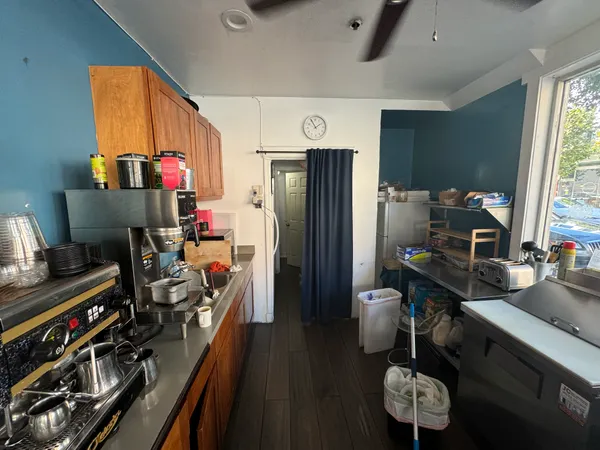 a kitchen with stainless steel appliances a stove refrigerator and a couch