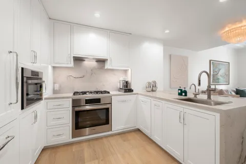 a kitchen with cabinets stainless steel appliances and sink