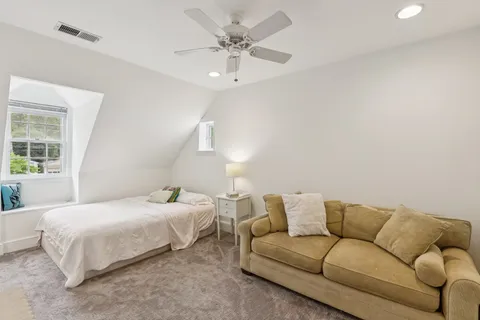 a bedroom with a bed couch and window