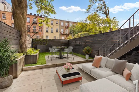 a roof deck with couch and potted plants