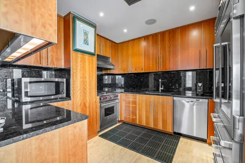 a kitchen with stainless steel appliances granite countertop a refrigerator and a stove top oven