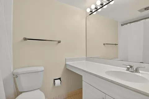a bathroom with a sink and mirror with toilet