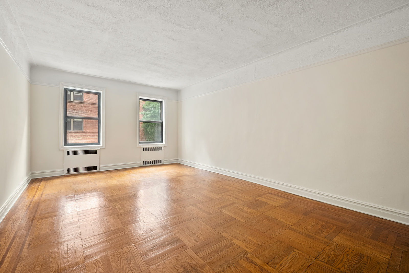 35-30 73rd Street, Unit 1F Queens, NY 11372 - Photo 2 of 10 a view of empty room with wooden floor and fan