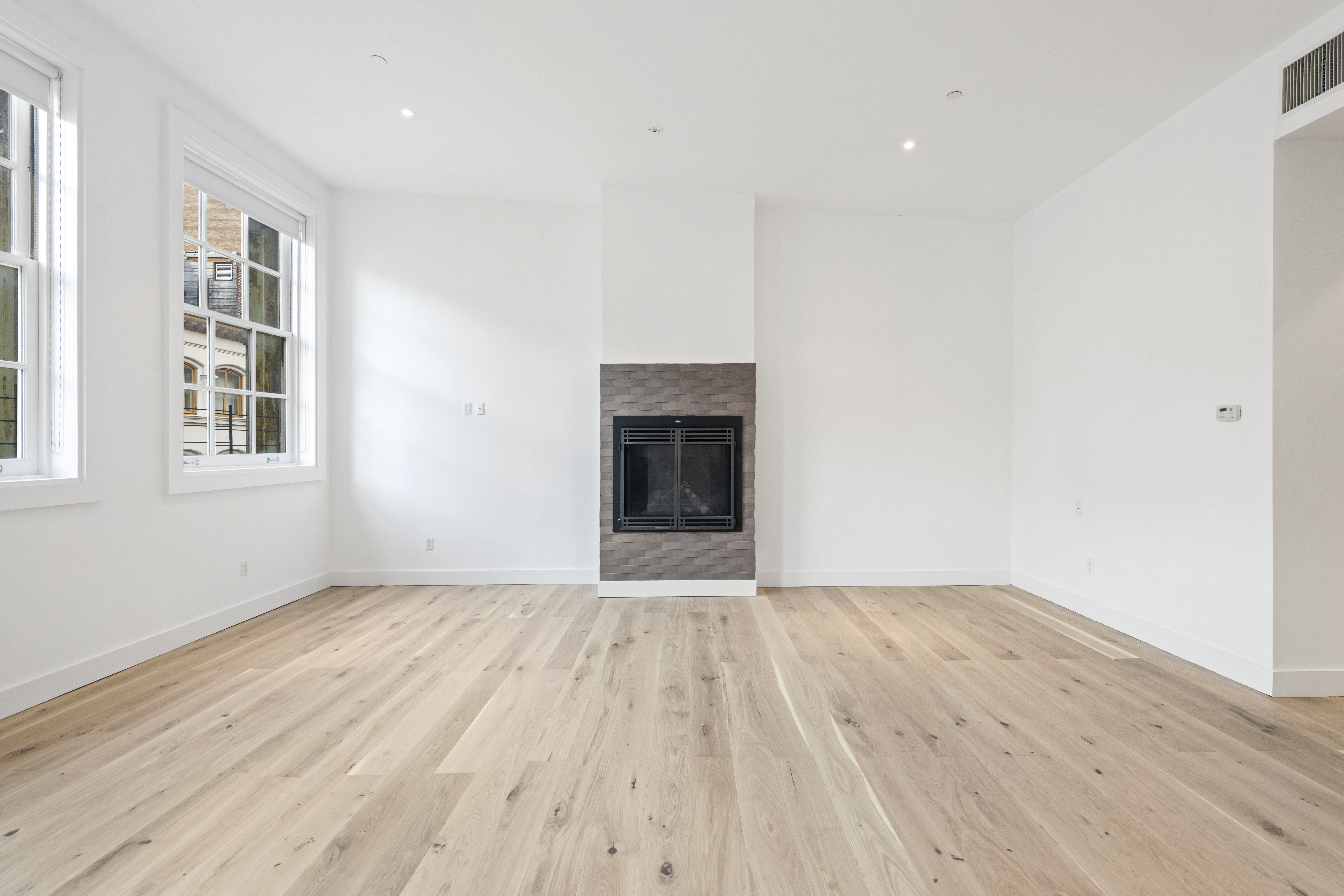 49 Walker Street, Unit PH Manhattan, NY 10013 - Photo 4 of 14 a view of an empty room with wooden floor and a window