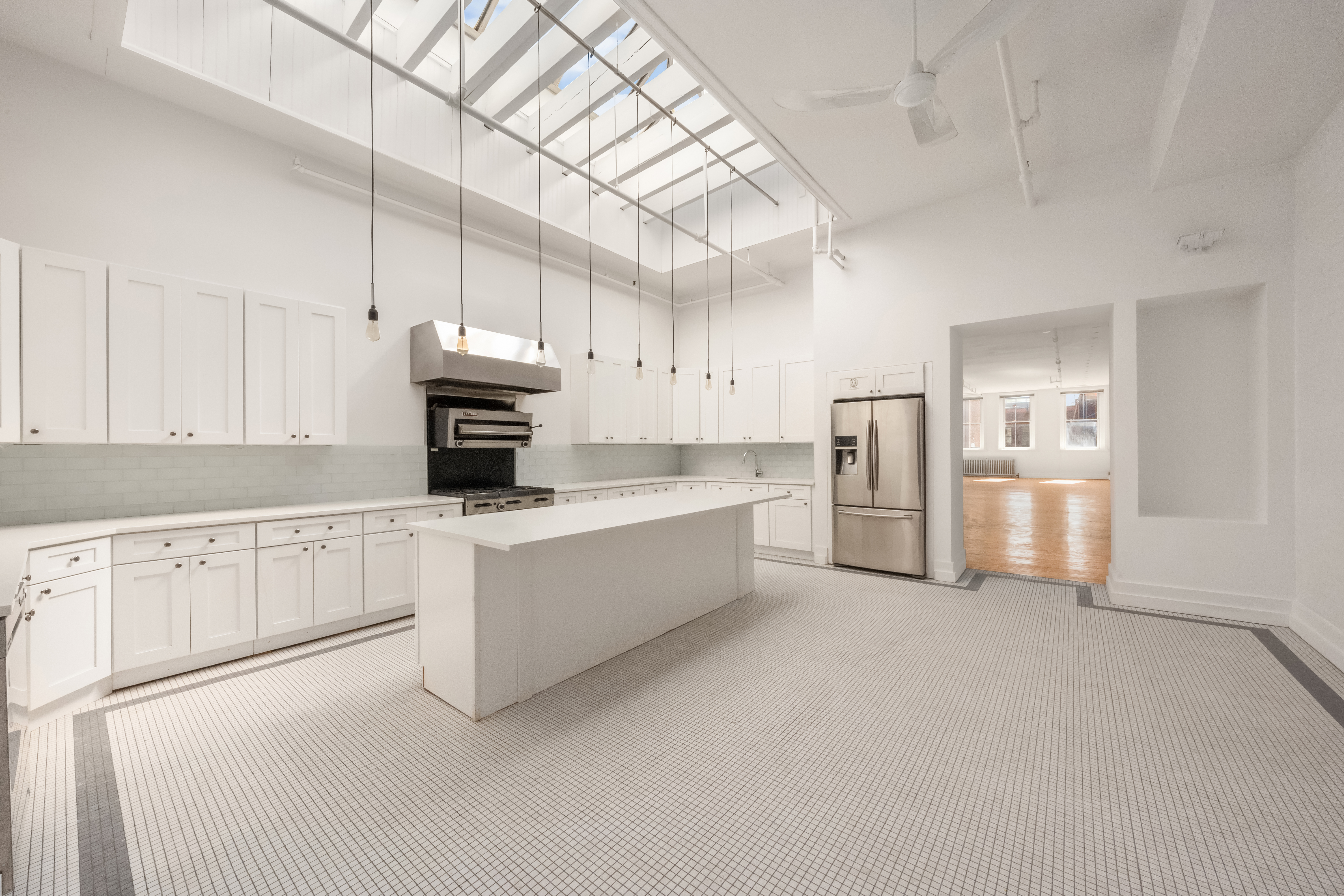 519 Broadway, Unit PHC Manhattan, NY 10012 - Photo 5 of 16 a large white kitchen with cabinets and stainless steel appliances