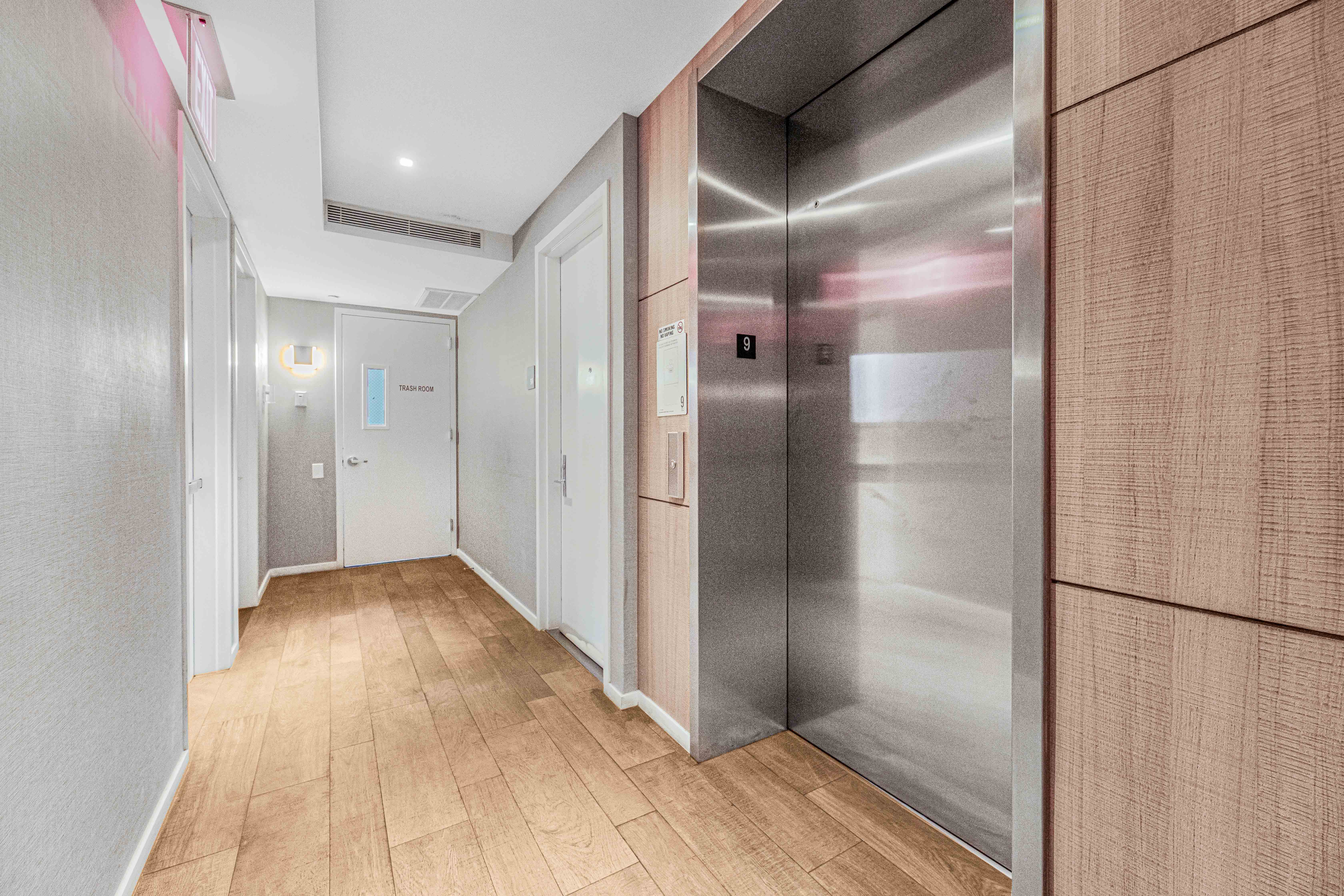 42-50 27th Street, Unit 9C Queens, NY 11101 - Photo 22 of 32 a view of hallway with stainless steel appliances wooden floor